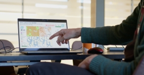 A person pointing to a screen showing floods map