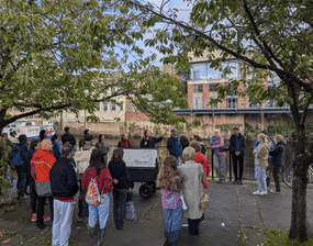 A group of people gather outside at North Street Gardens