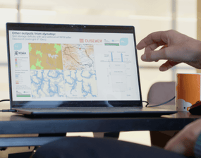A person showcasing modelling results from DynaTop on a laptop screen