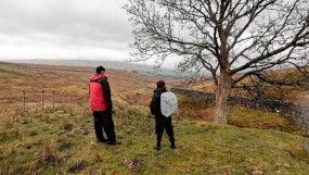 Nick and Ruth standing looking over a field with their backs to the camera